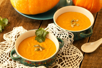 Traditional pumpkin soup on lace doily and wooden table