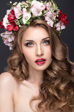 beautiful blond girl with curls and wreath of purple flowers on