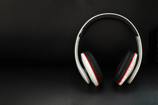 Bluetooth headphones on black leather background