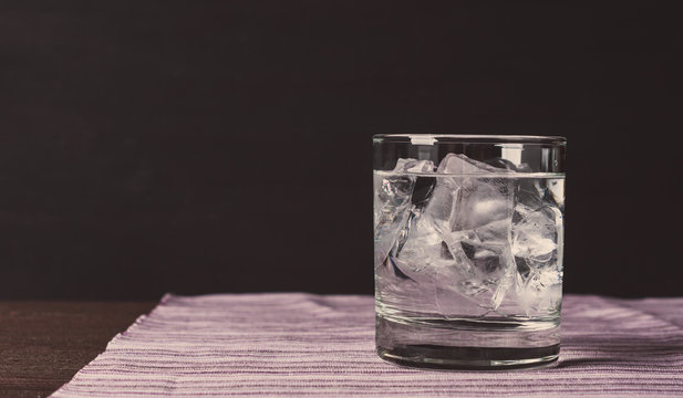 Glass of vodka on the rocks. Vintage style. Toned image.