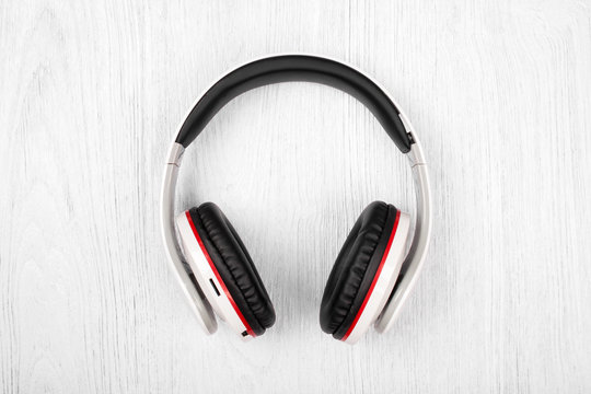 Bluetooth headphones on white wood background