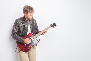 young guitarist in leather jacket playing