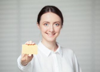 Smiling young woman showing a plastic golden card