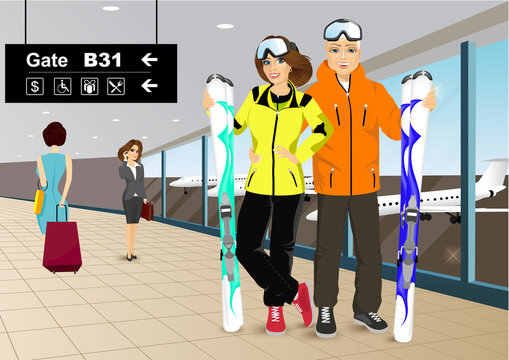 happy couple skiers standing in the hall of the airport