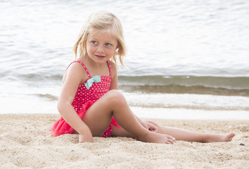 Fototapeta na wymiar Little Girl Sunbathing on the Beach