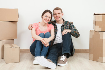 Fototapeta na wymiar Happy young man and woman sitting near cardboard boxes