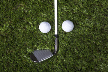 Golf club and balls on green grass