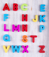 colorful plastic English alphabet on a white wooden background