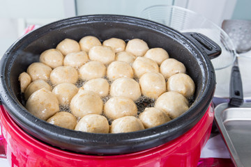 Meatball are fried in a pan with oil.
