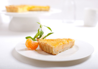 Tangerine creme brulee tart on a white background