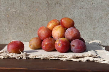 Small group of plums on the wood table.
