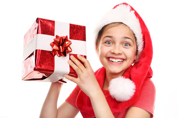 Świąteczne marzenia, Magiczny czas świąt. Szczęśliwe dziecko w czapce św. Mikołaja z zapakowanym prezentem - obrazy, fototapety, plakaty