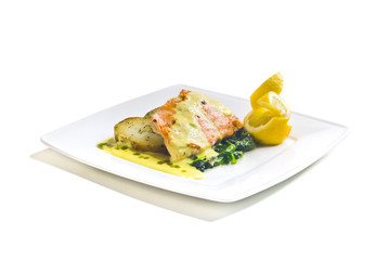Grilled salmon with fried potatoes, spinach and butter sauce