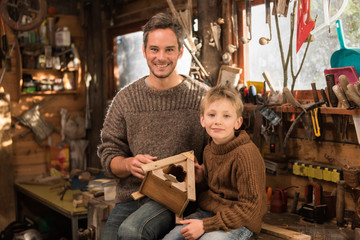 father and his little son working a rustic wooden workshop 