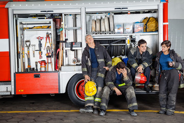 Fototapeta premium Team Of Exhausted Firefighters At Station