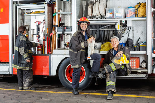 Confident Firefighters By Truck At Fire Station
