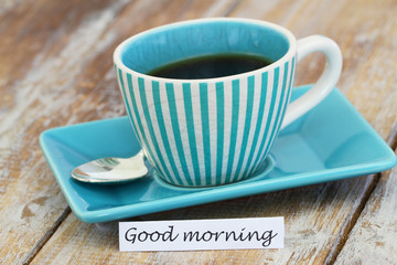 Good morning card with cup of espresso coffee on rustic wooden surface
