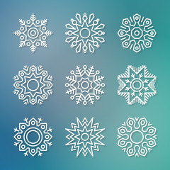 Set of flat line vector paper snowflakes with shadows on blue blurred background. Christmas and New Year decoration element. Simple shape template for graphic design