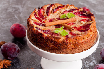 Homemade pie with plums on the table and fresh plums