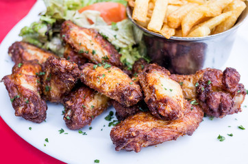 Chicken wings with sauce and golden French fries potatoes