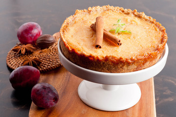 Plum pie, spices and plums decorated with mint and cinnamon on a