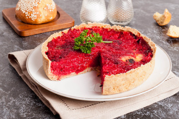 Tartlet with beetroot, parsley and goat cheese on a white plate