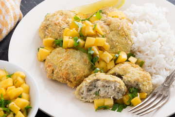 Thai fish cakes with mango salsa and rice on a plate