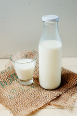 
A light breakfast of milk products , cottage cheese, sour cream and milk, roll and butter on a wooden background