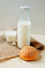 
A light breakfast of milk products , cottage cheese, sour cream and milk, roll and butter on a wooden background