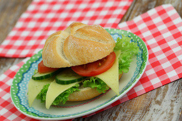 Cheese roll on plate on red and white checkered napkins
