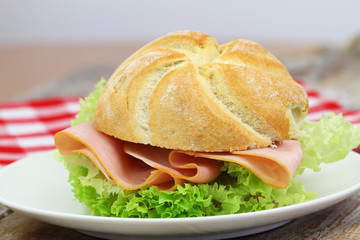 Freshly backed ham roll with lettuce, closeup
