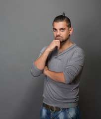 Thoughtful fashionable hipster man in studio