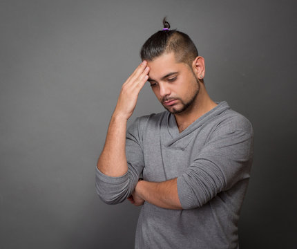 Thoughtful fashionable hipster man in studio