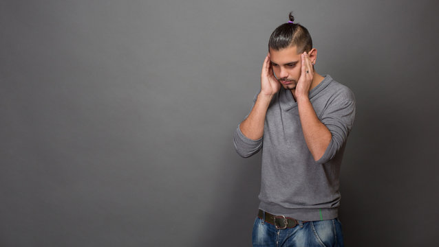 Thoughtful fashionable hipster man in studio