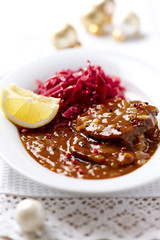 Pork roast with onion-mushroom sauce and red cabbage seeds for Christmas