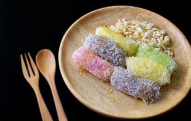 colorful traditional thai dessert on wood dish with black background
