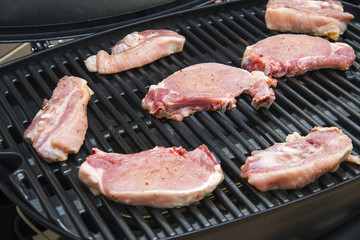 Raw meat on a gas grill

