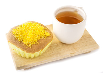 golden egg cake with hot tea on the wood table