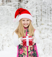 young girl with red hat holds out a gift