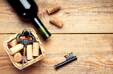 Basket with wine corks and corkscrew on a wooden table