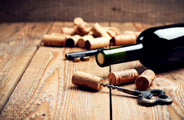 Fototapeta na wymiar Wine corks, bottle and corkscrew on a wooden table