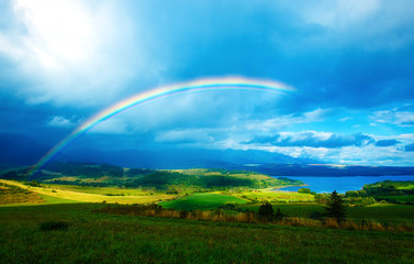  meadow and lake with mountain on background  a rainbow 