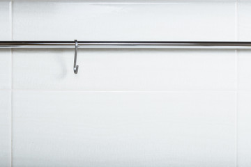 Metal hooks on a chromed tube.

