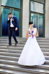 Naklejka premium the bride and groom on the background of glass building