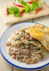 pork fried rice and fried egg with basil and chili background