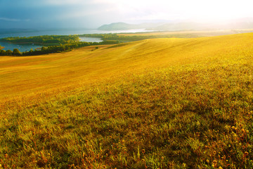 Fototapeta na wymiar Beautiful landscape, yellow meadow and lake with mountains 