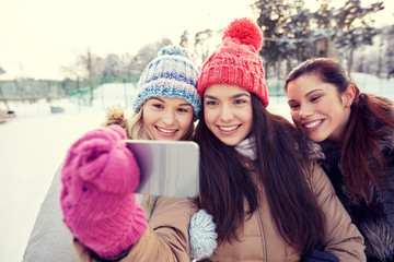 Fototapeta premium happy teenage girls taking selfie with smartphone