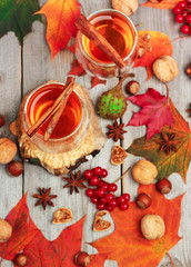 Autumn hot beverage in a glass with fruits and spices