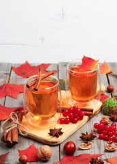 Autumn hot beverage in a glass with fruits and spices