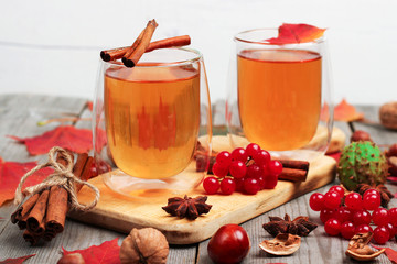 Autumn hot beverage in a glass with fruits and spices